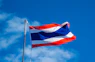 a red, white and blue flag flying in the wind