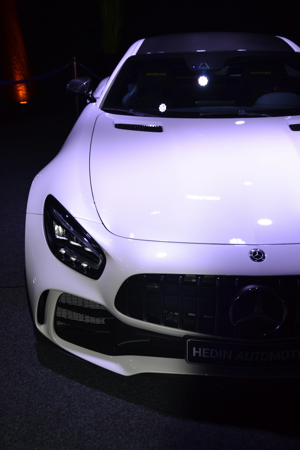 a white mercedes sports car on display at a show