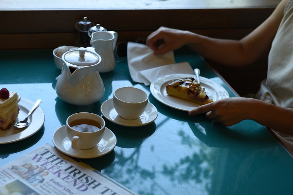 uma mesa coberta com pratos de comida e xícaras de café