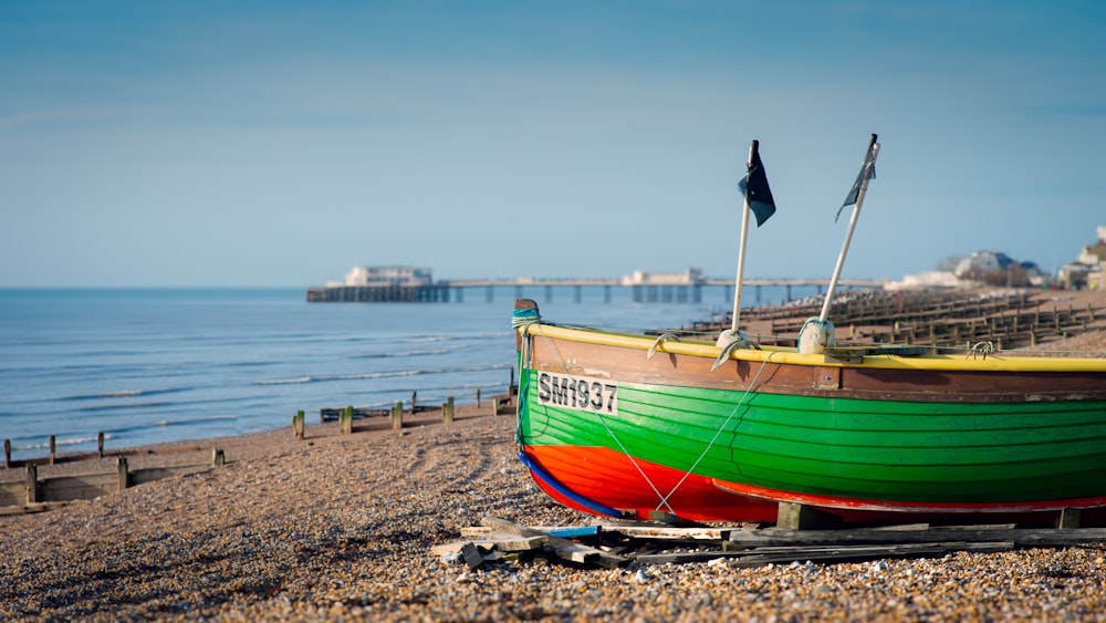 a boat sitting on top of a beach next to the ocean