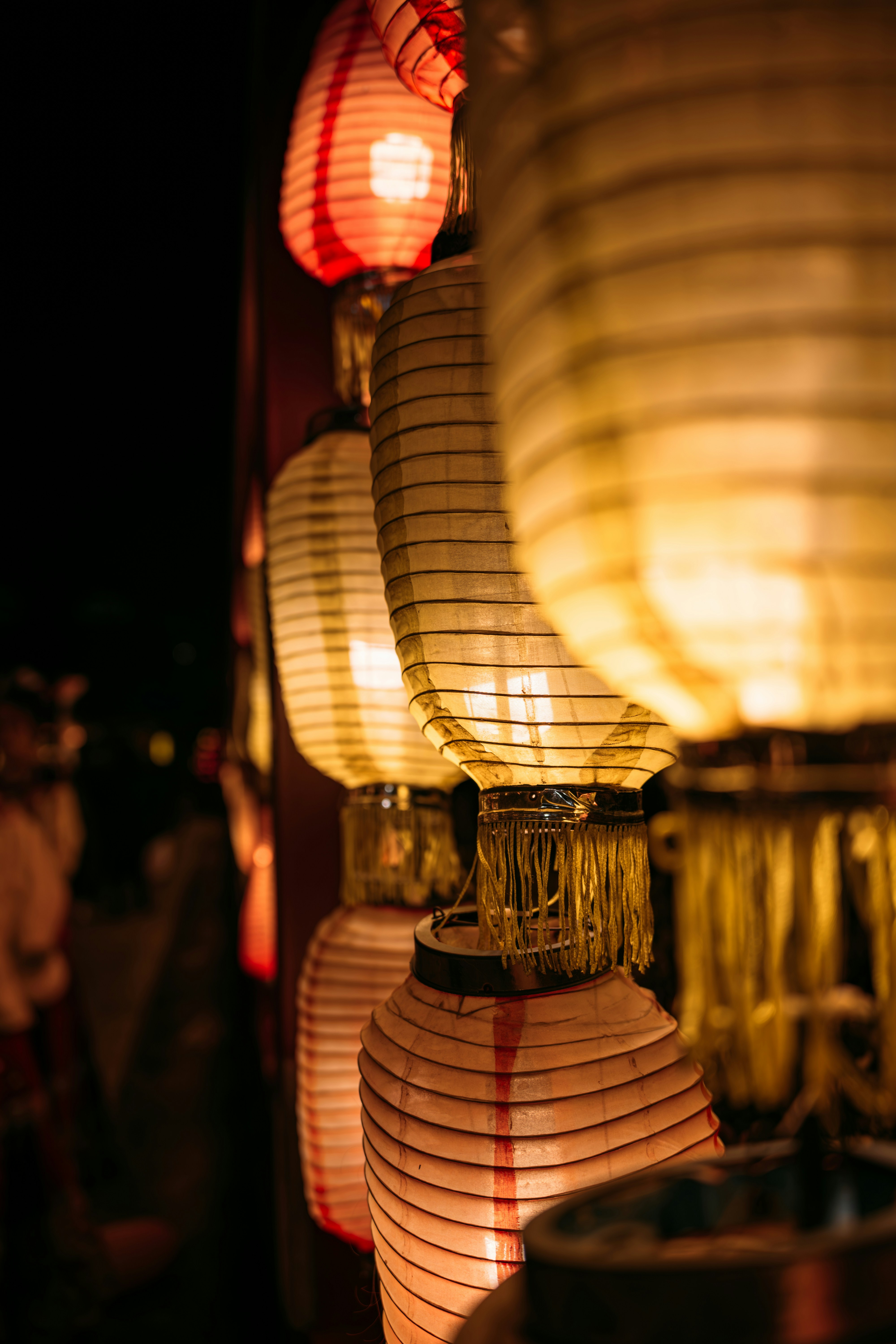 People in festival kimono at rural shrine with lanterns