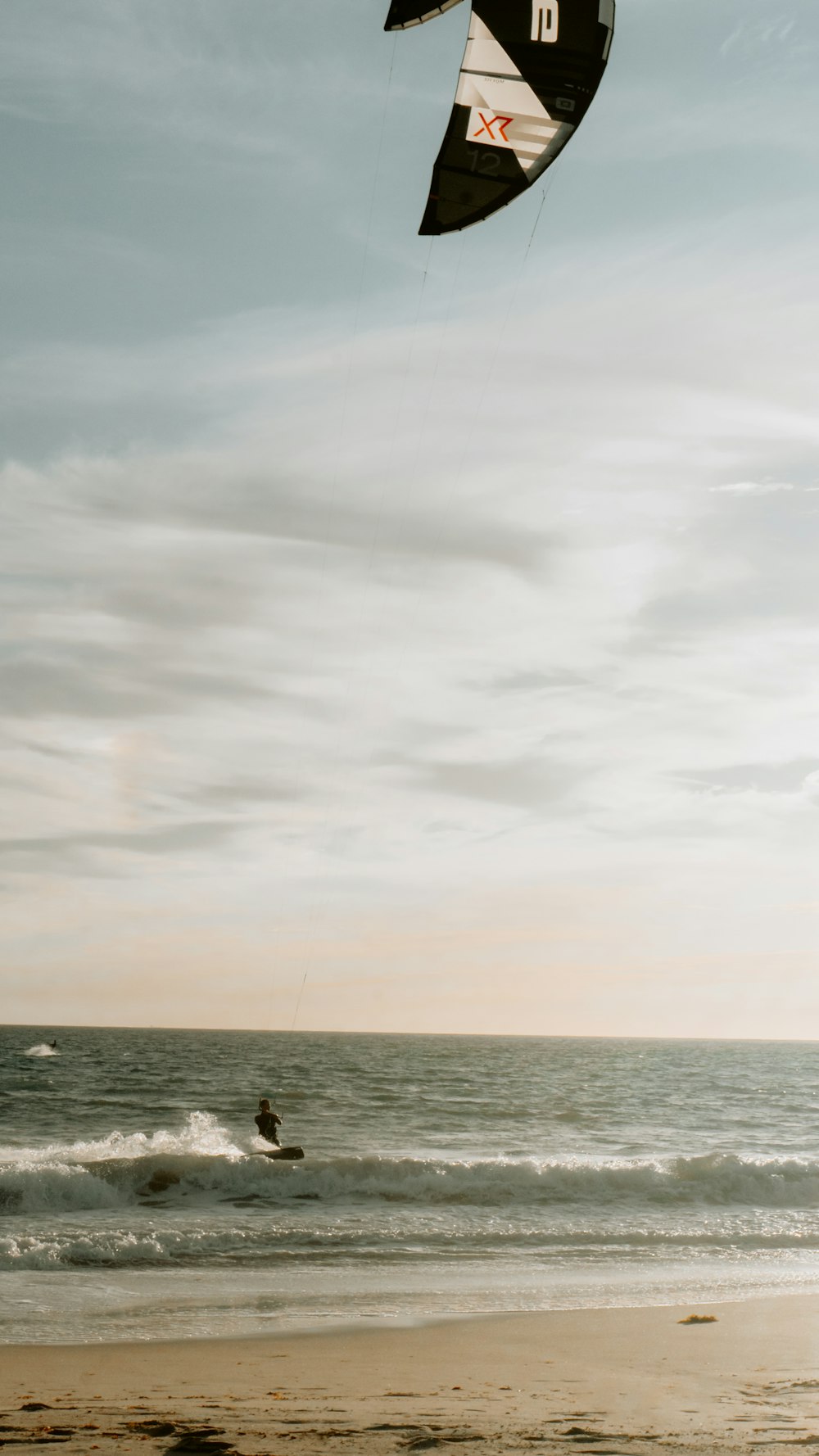 a person on a beach flying a kite