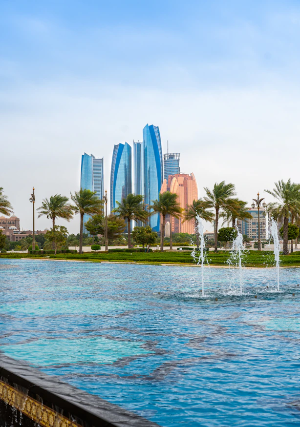 a fountain in front of a city skyline