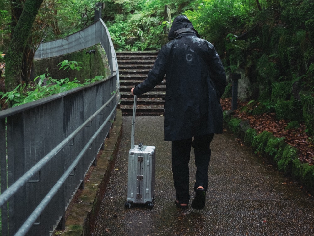 a person walking down a path with a suitcase