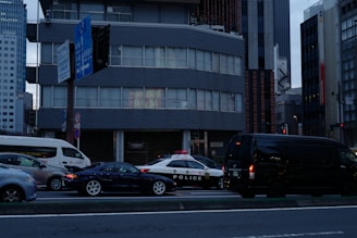 a city street filled with lots of traffic next to tall buildings