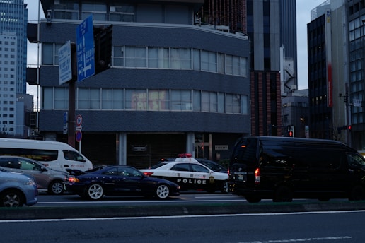 a city street filled with lots of traffic next to tall buildings