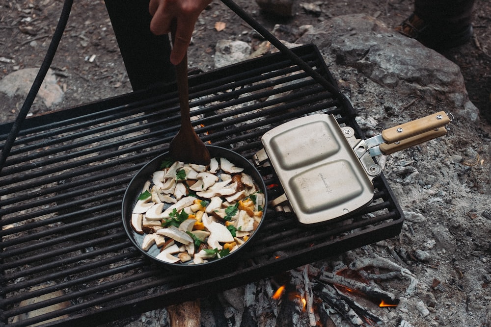 une personne fait cuire des aliments sur un gril