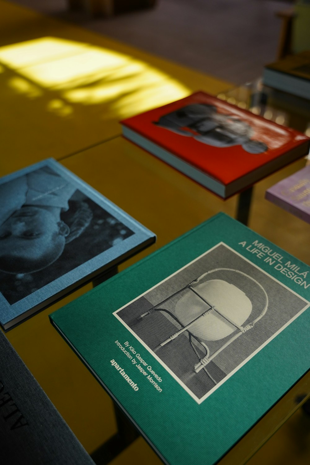 a table topped with three books on top of a wooden table