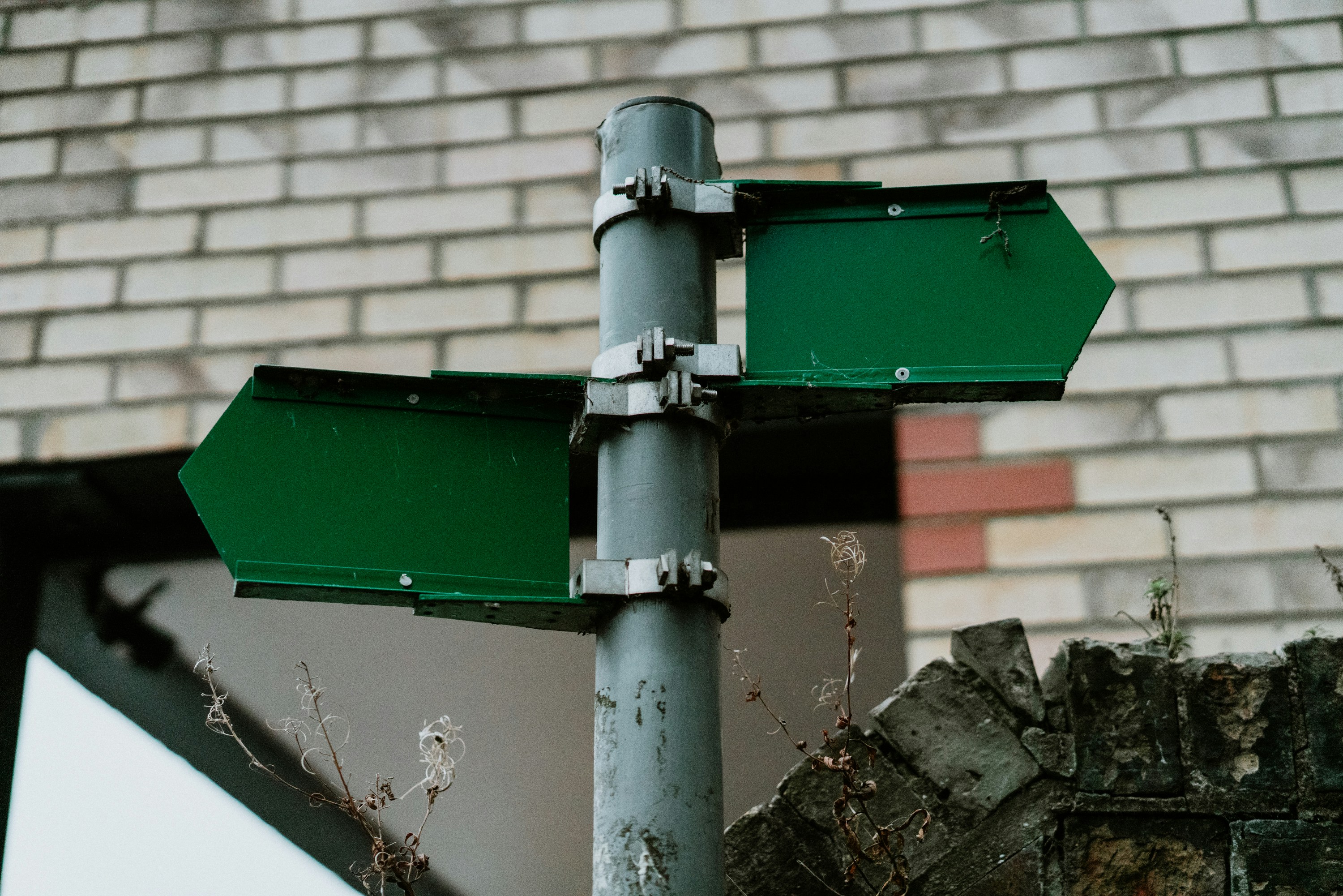 a green street sign sitting next to a brick wall