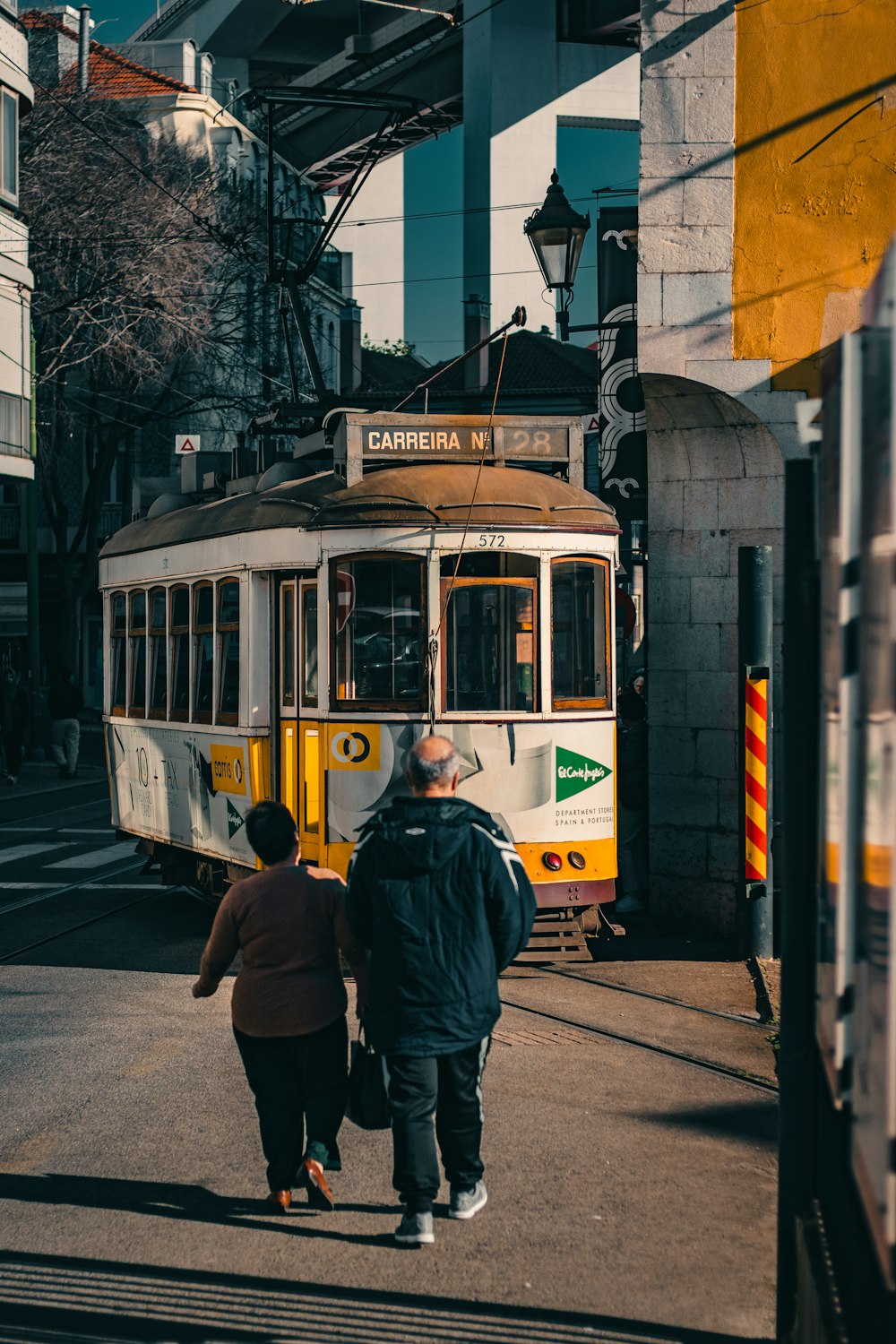 a man and a woman walking towards a trolley