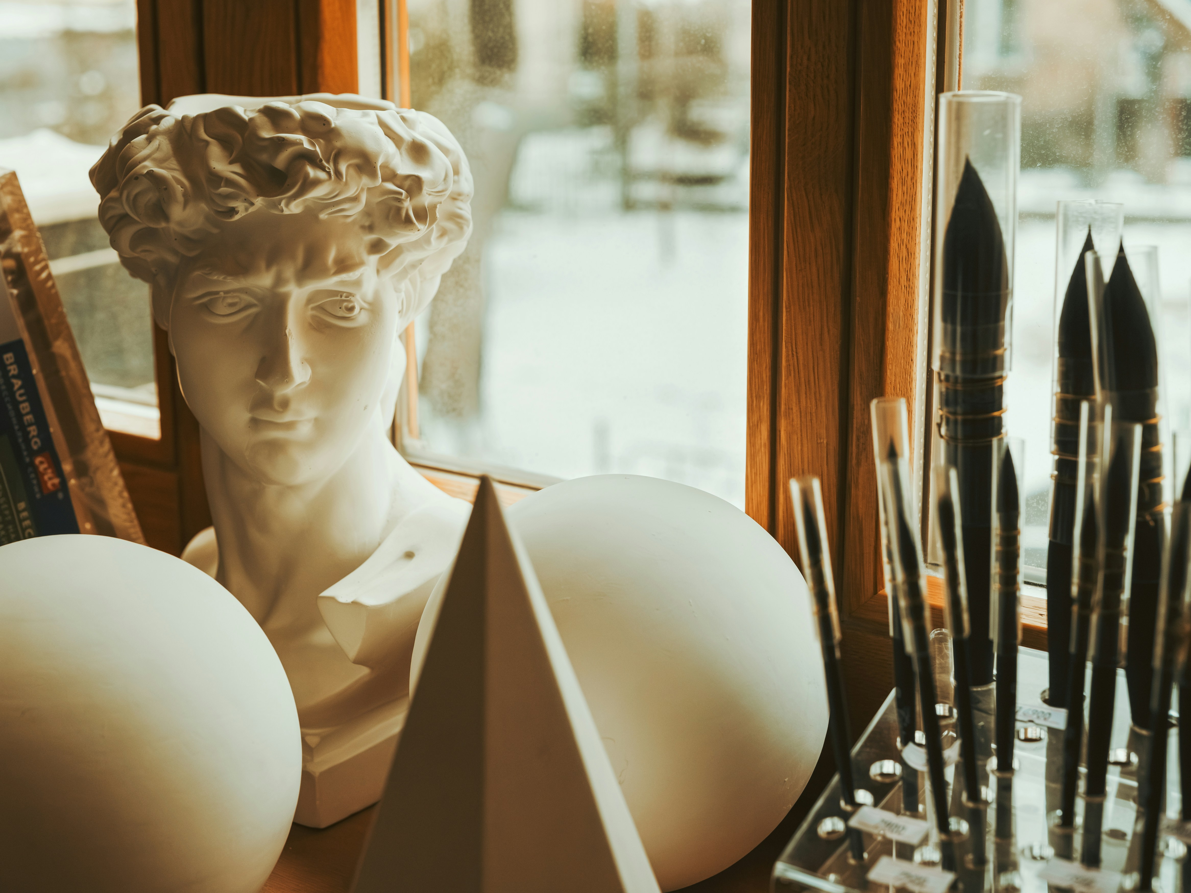 eine Statue eines Manneskopfes neben einem Fenster