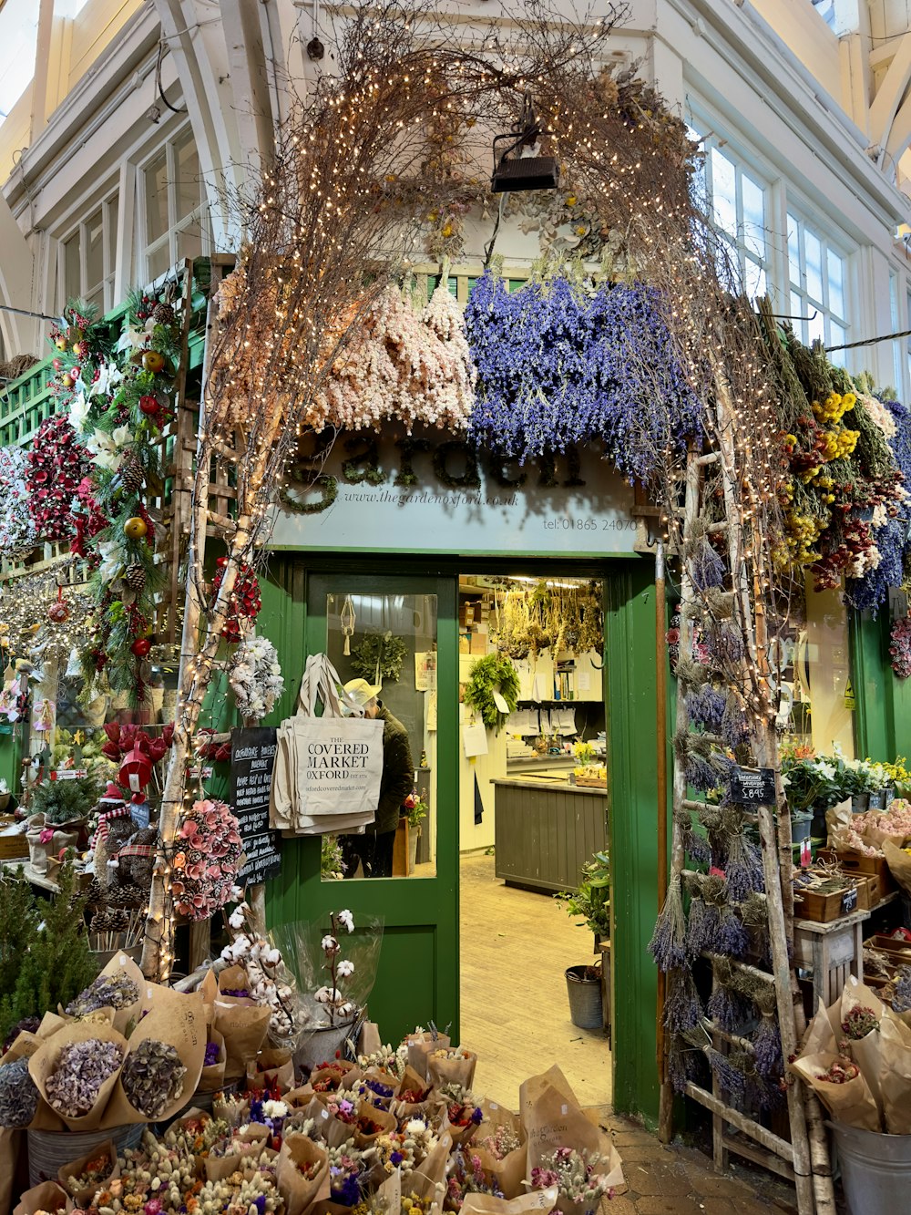 a store with a bunch of flowers hanging from the ceiling