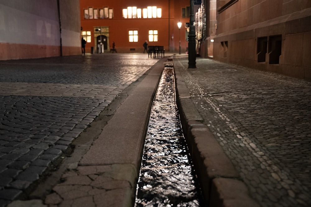 a city street with a puddle of water in the middle of it