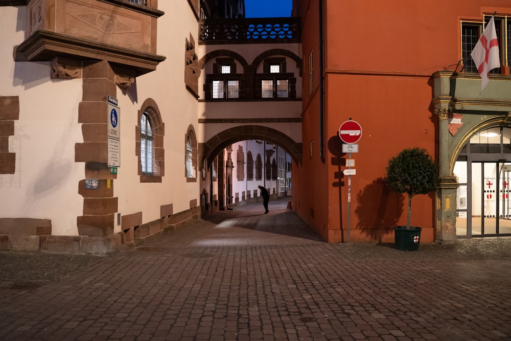 a person is walking down a cobblestone street