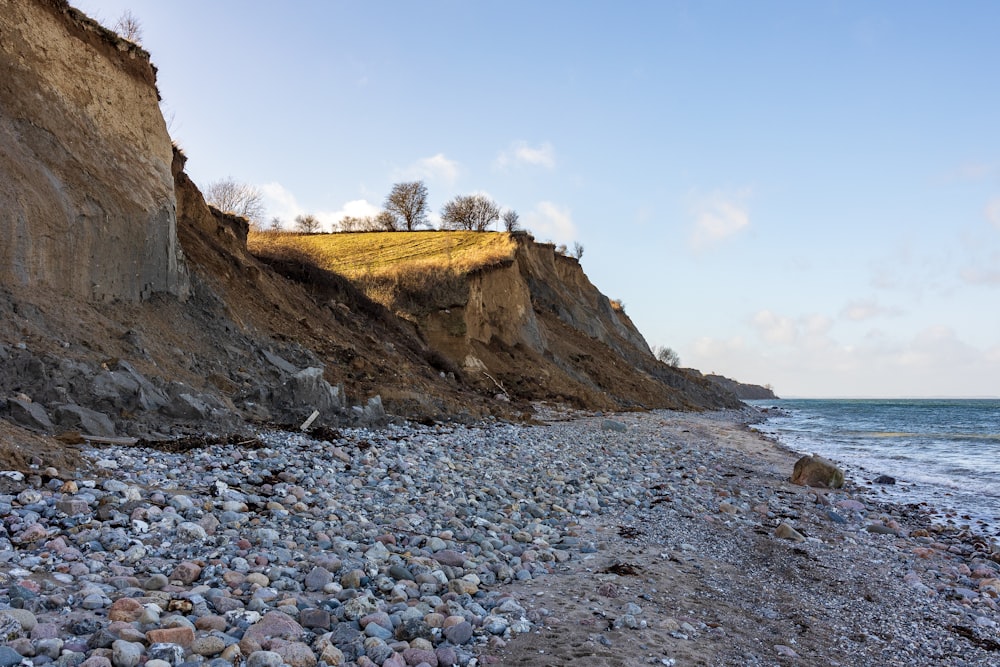 Ein felsiger Strand neben einer Klippe an einem sonnigen Tag