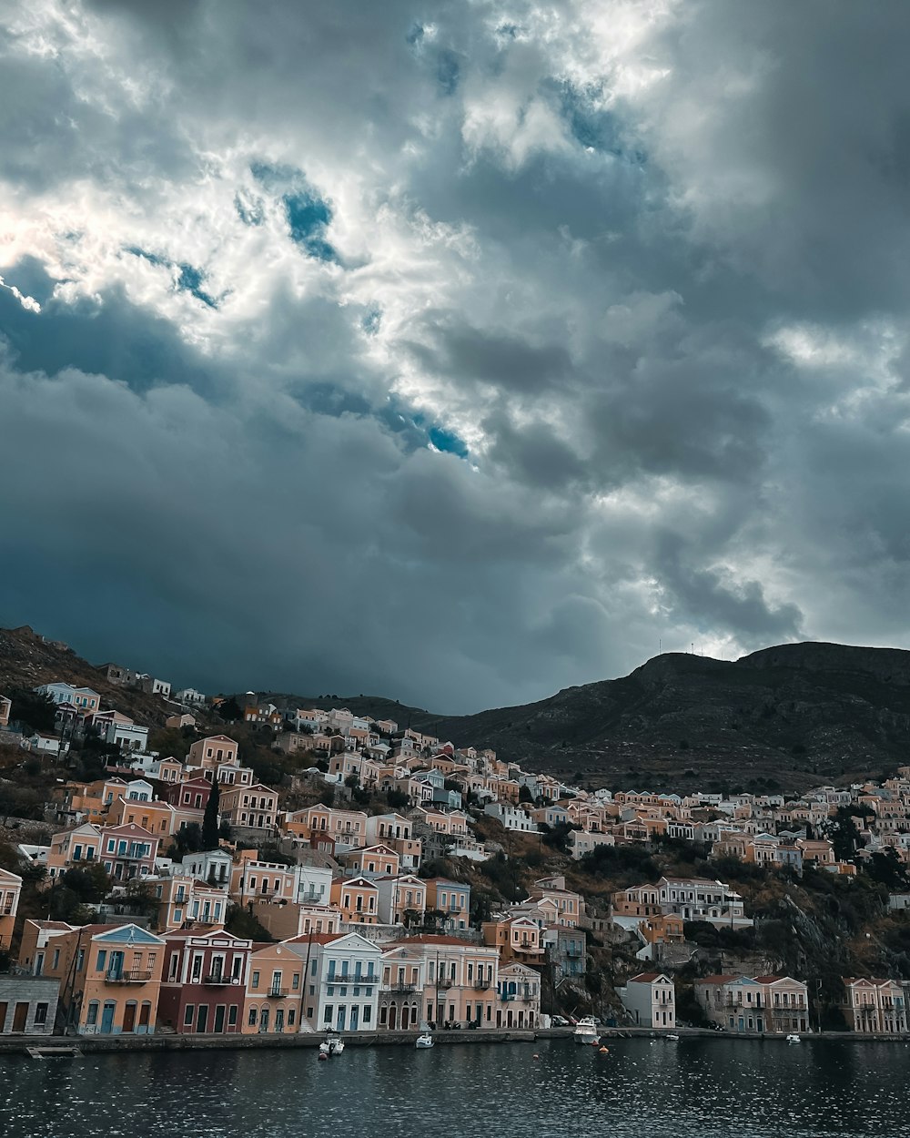 a cloudy sky over a small town on the shore