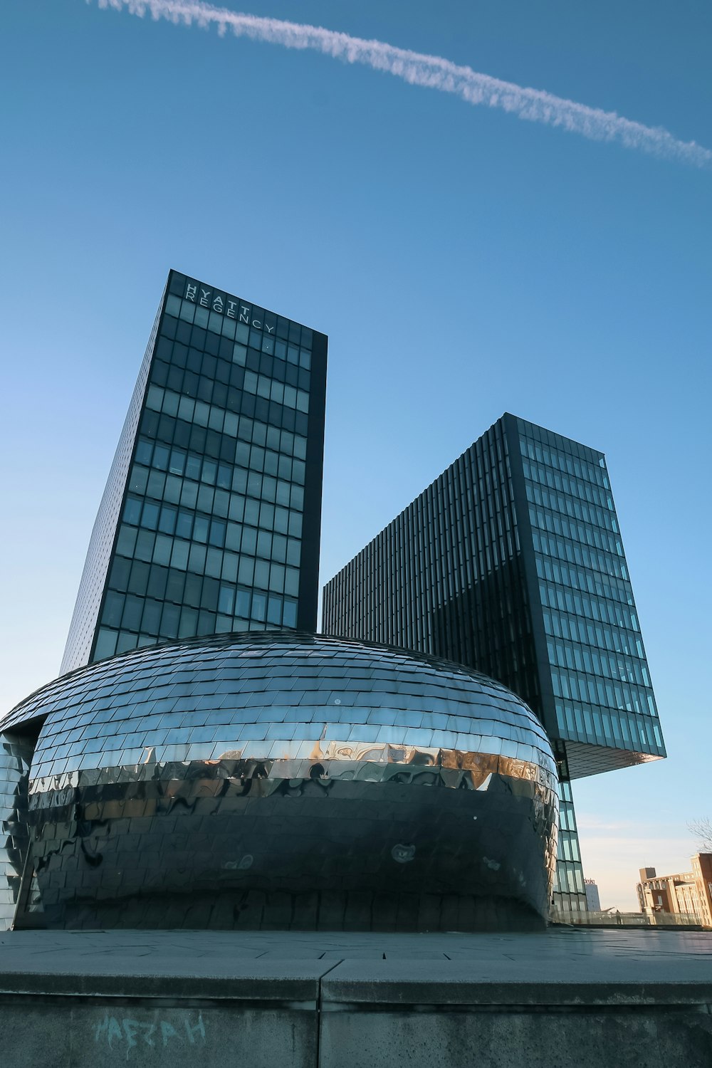 a very tall building with two very tall buildings in the background