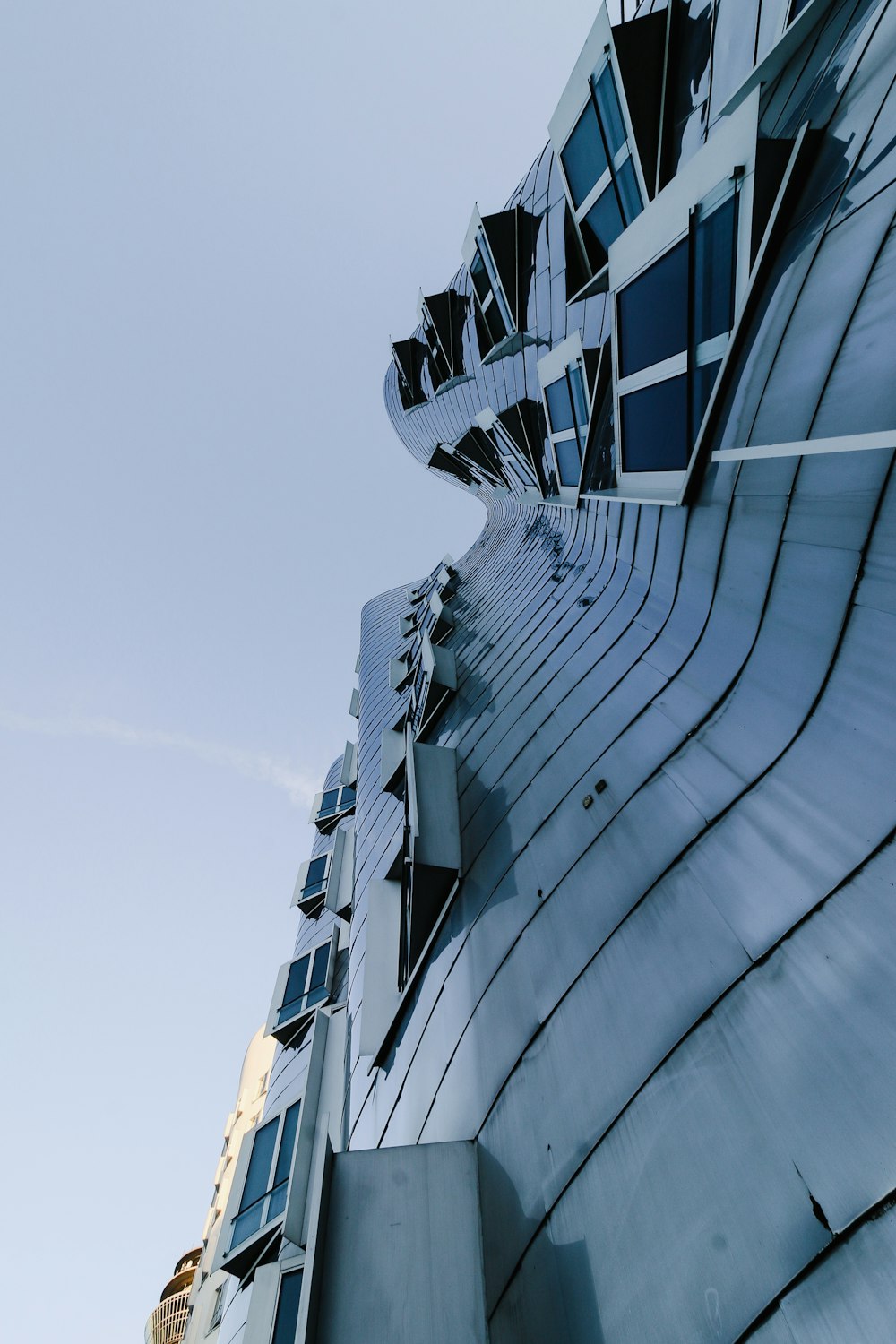 a very tall building with many windows and a sky background