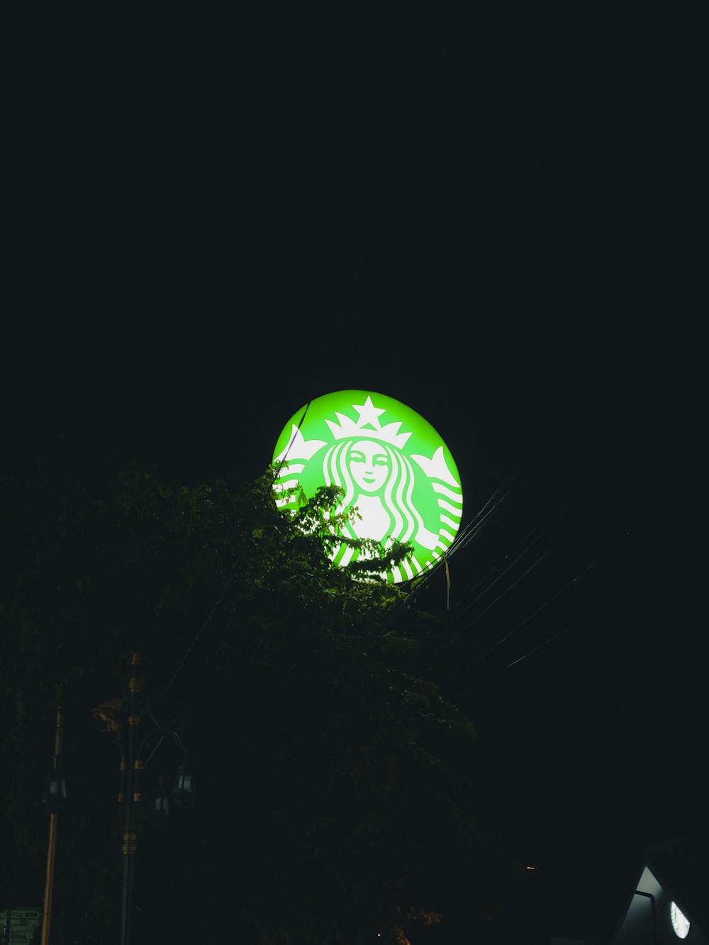 a lit up starbucks sign in the dark