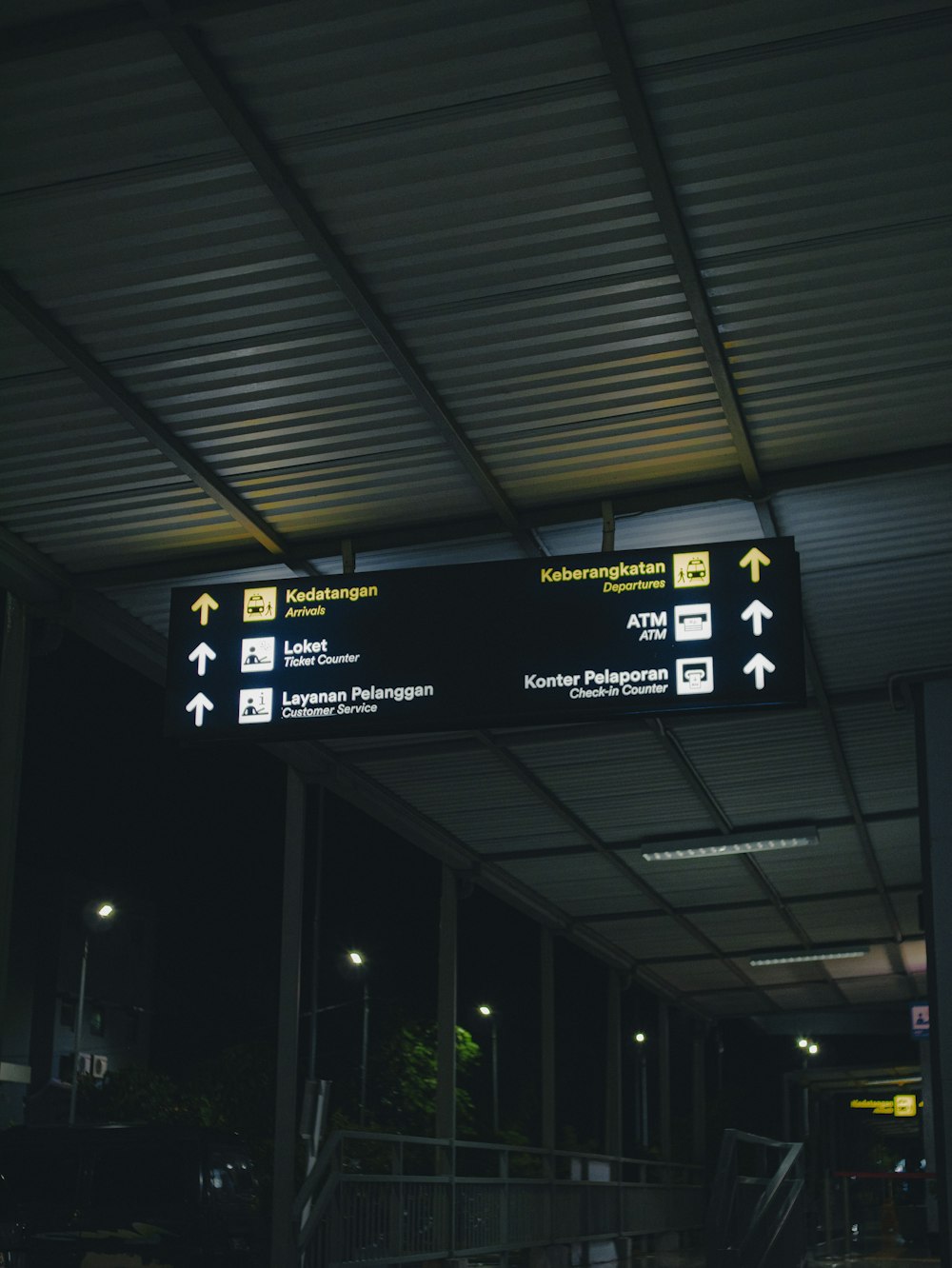 a black and white photo of a train station sign