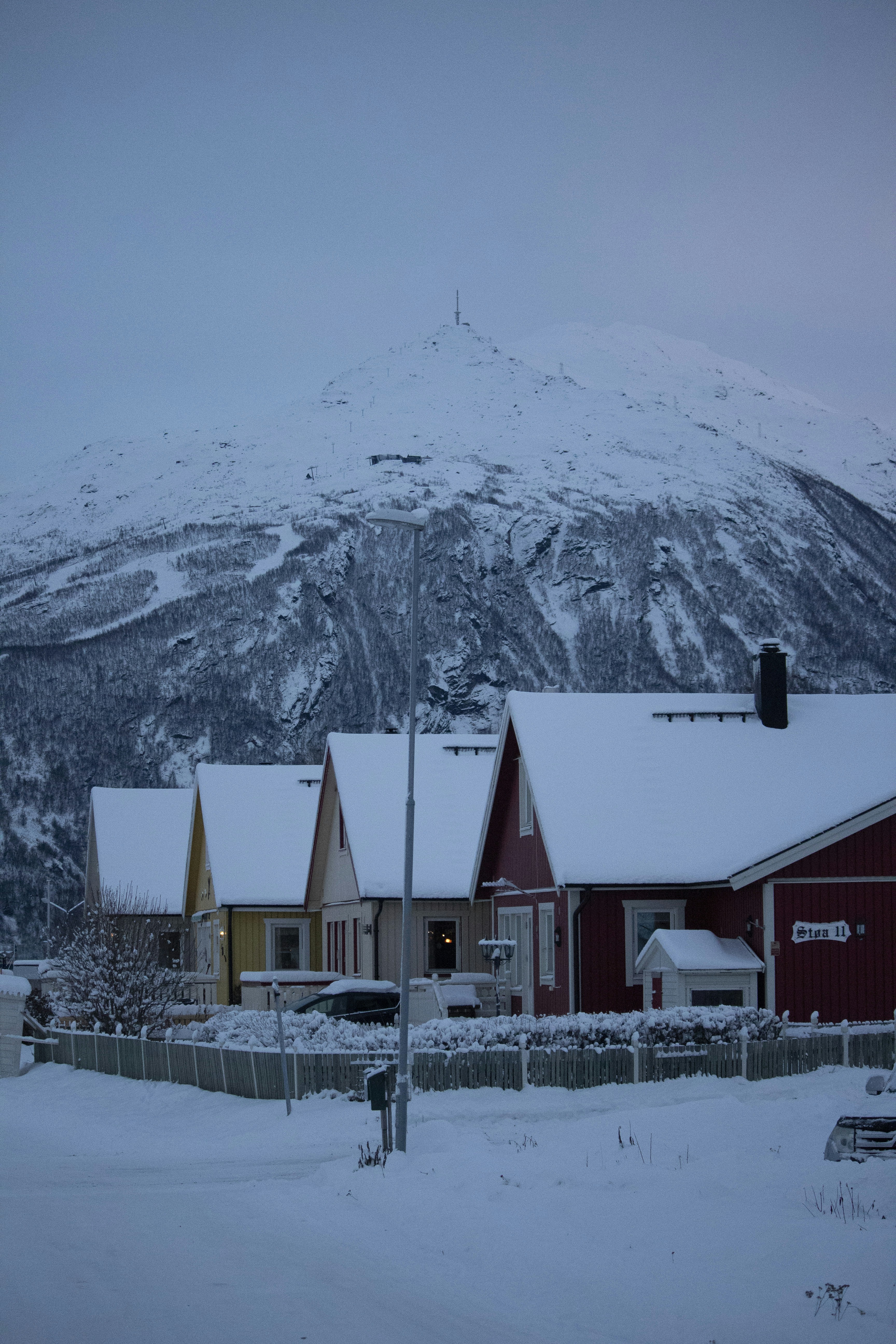 a snow covered mountain in the background with houses in the foreground