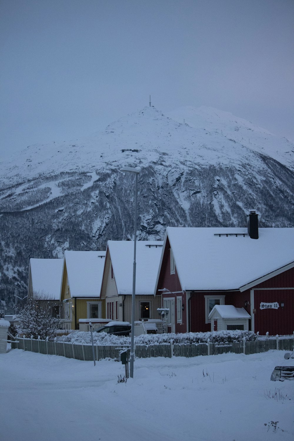 a snow covered mountain in the background with houses in the foreground