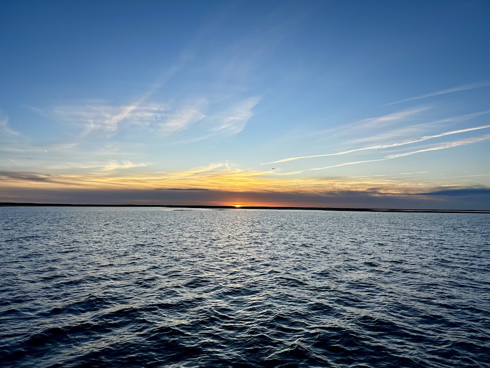 a body of water with a sky in the background