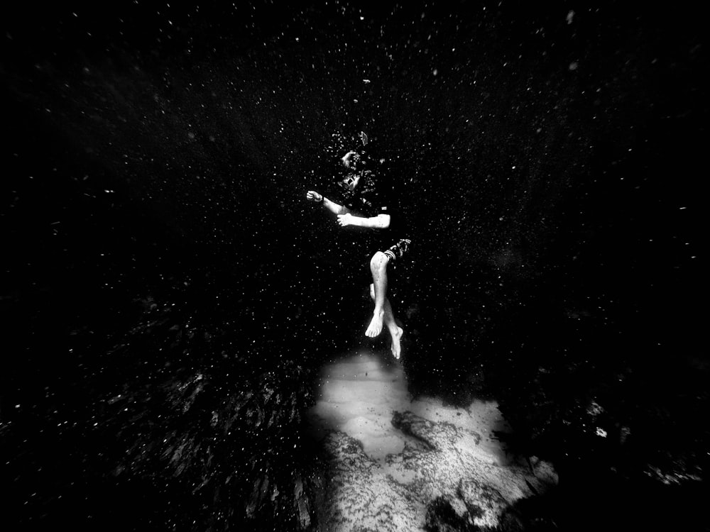 a black and white photo of a person floating in the water