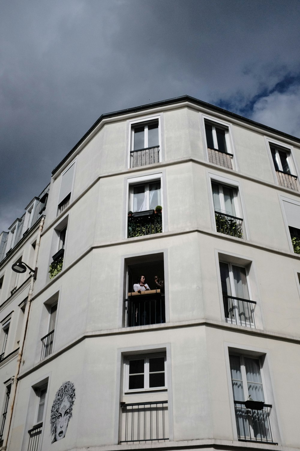 a tall white building with balconies and balconies on the windows