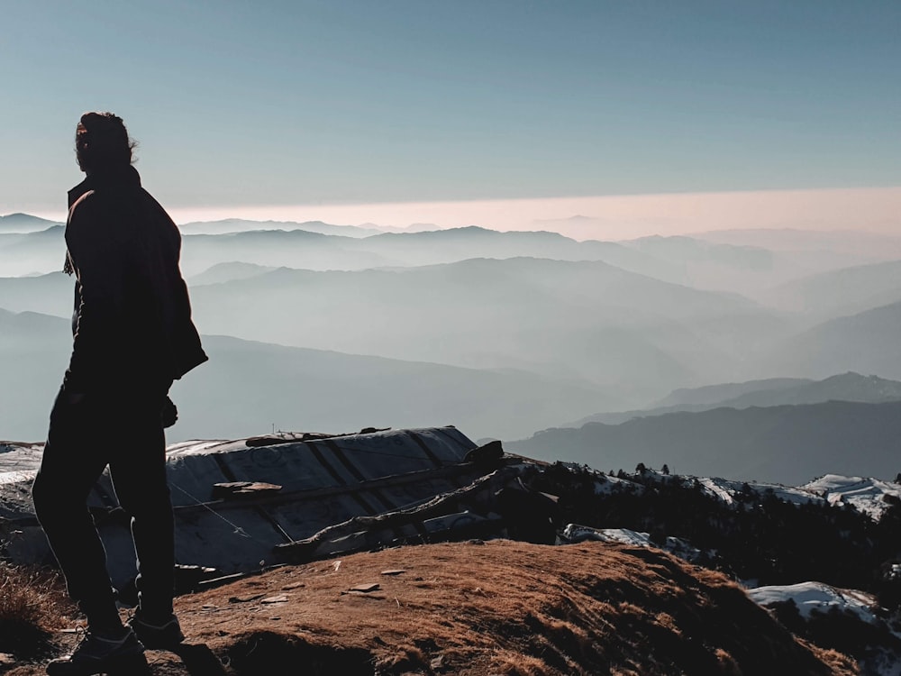 a man standing on top of a mountain overlooking a valley