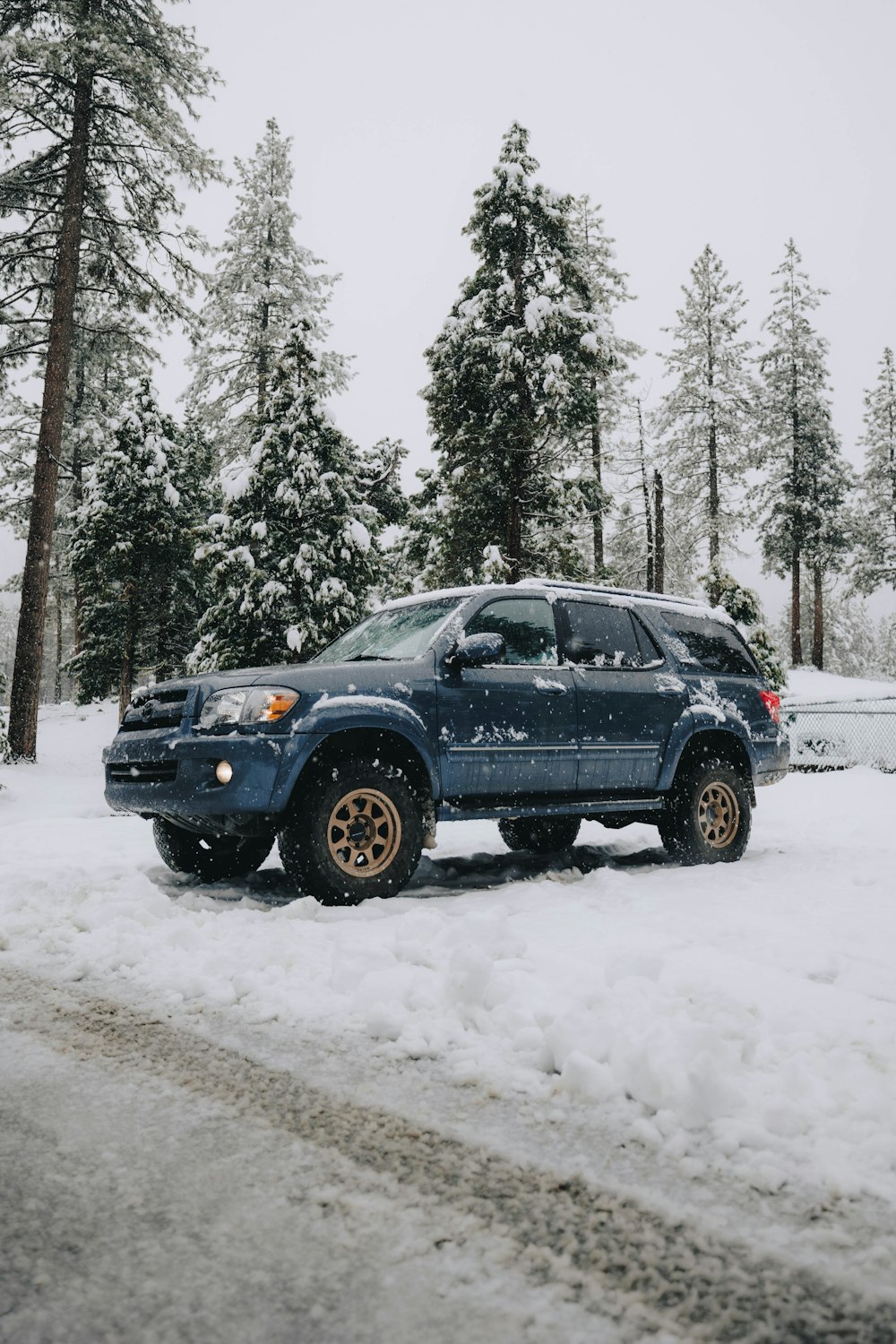 a blue truck parked on a snowy road