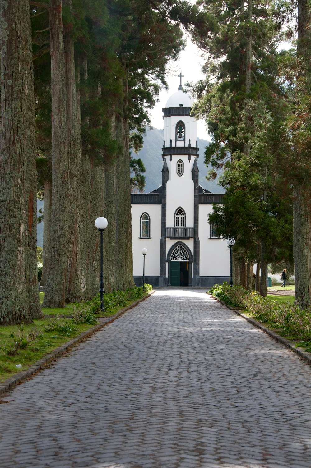 eine weiß-schwarze Kirche, umgeben von Bäumen