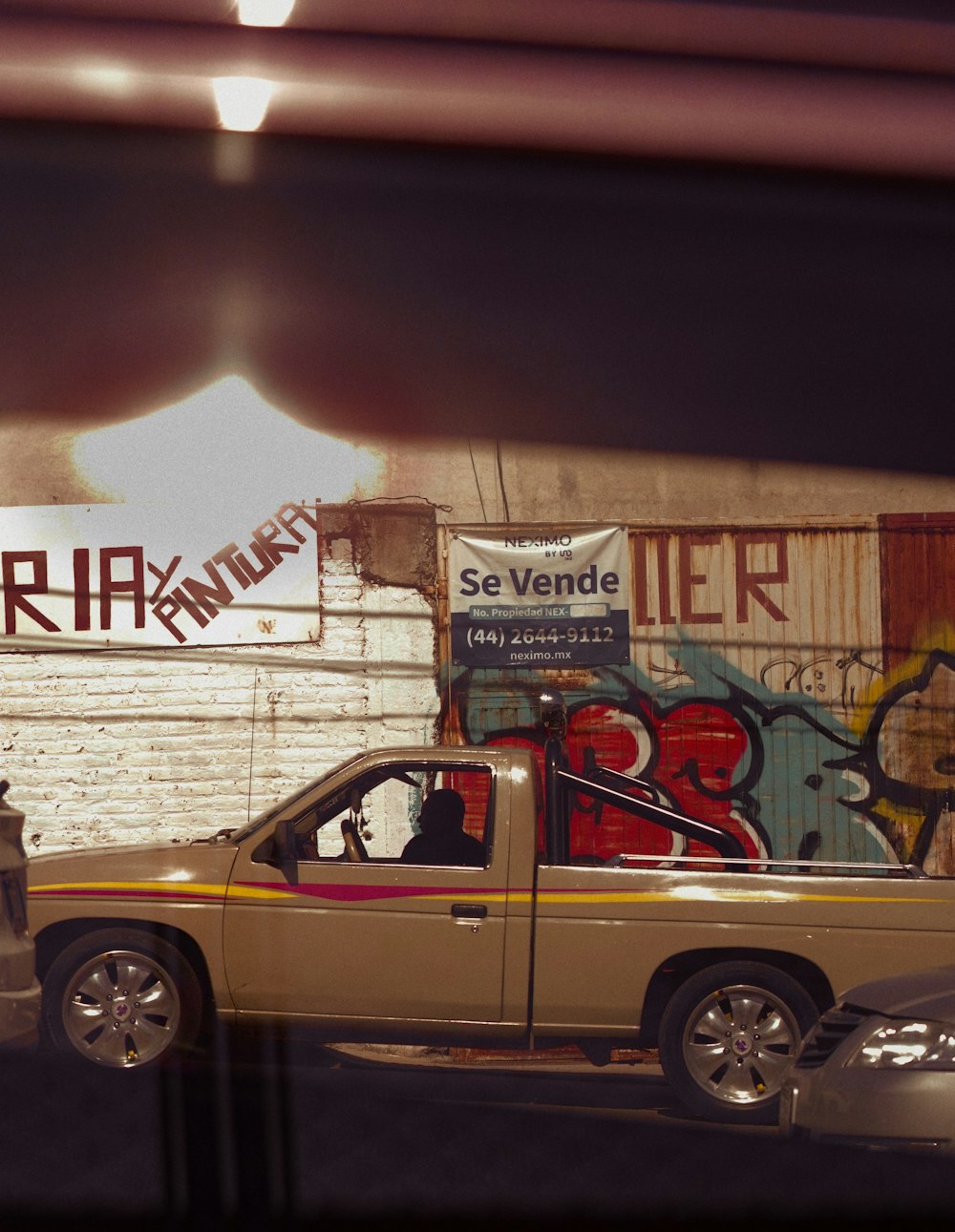 a pickup truck parked in front of a graffiti covered wall