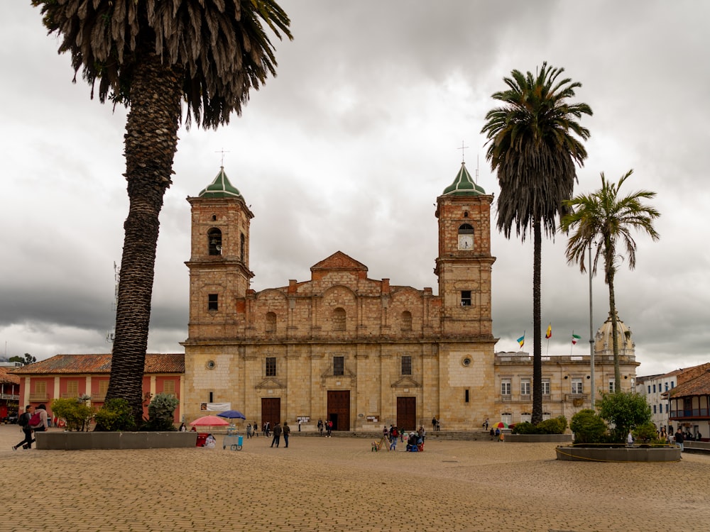 a large building with two towers surrounded by palm trees