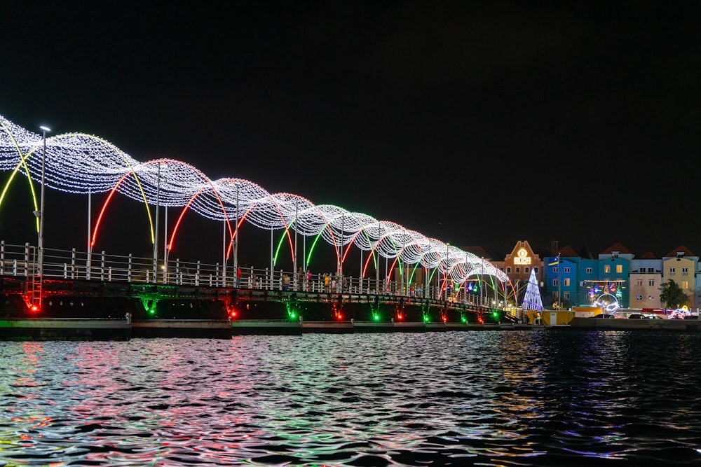 a lighted bridge over a body of water at night