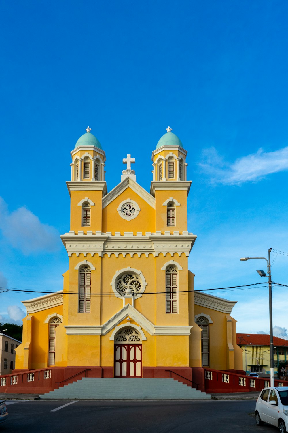 a large yellow church with a clock on the front