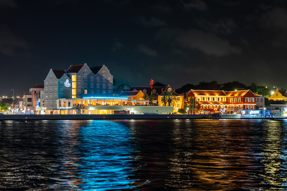 a large body of water at night with buildings in the background