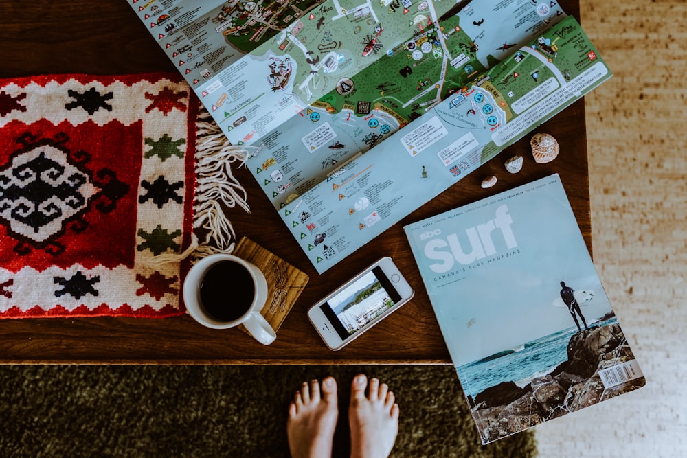 a person standing next to a map and a cup of coffee