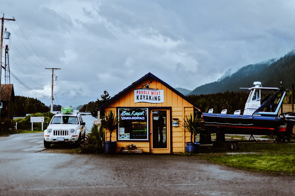 a small yellow building with a boat on top of it