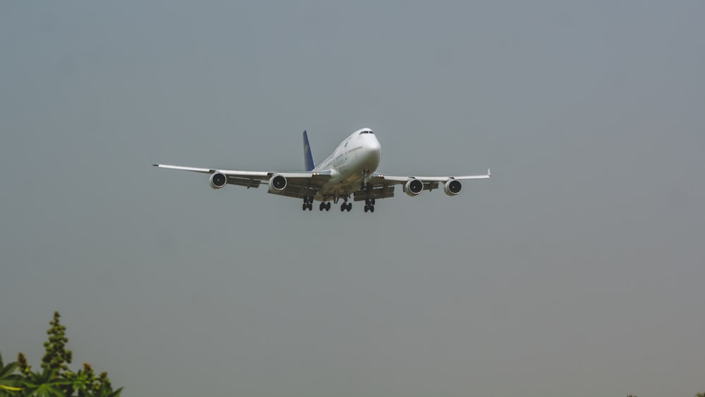 a large jetliner flying through a gray sky