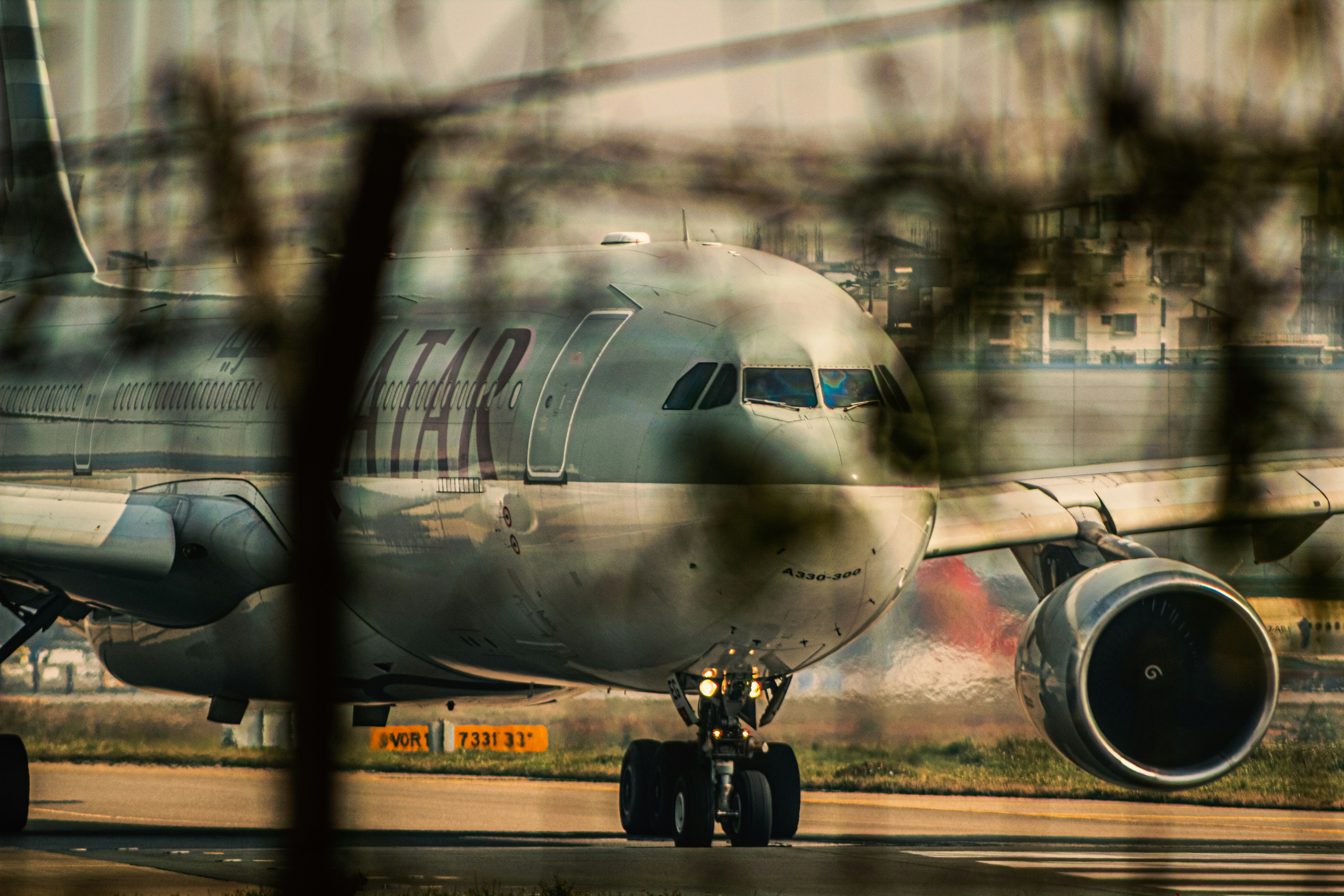 a large jetliner sitting on top of an airport tarmac, Qatar a330.