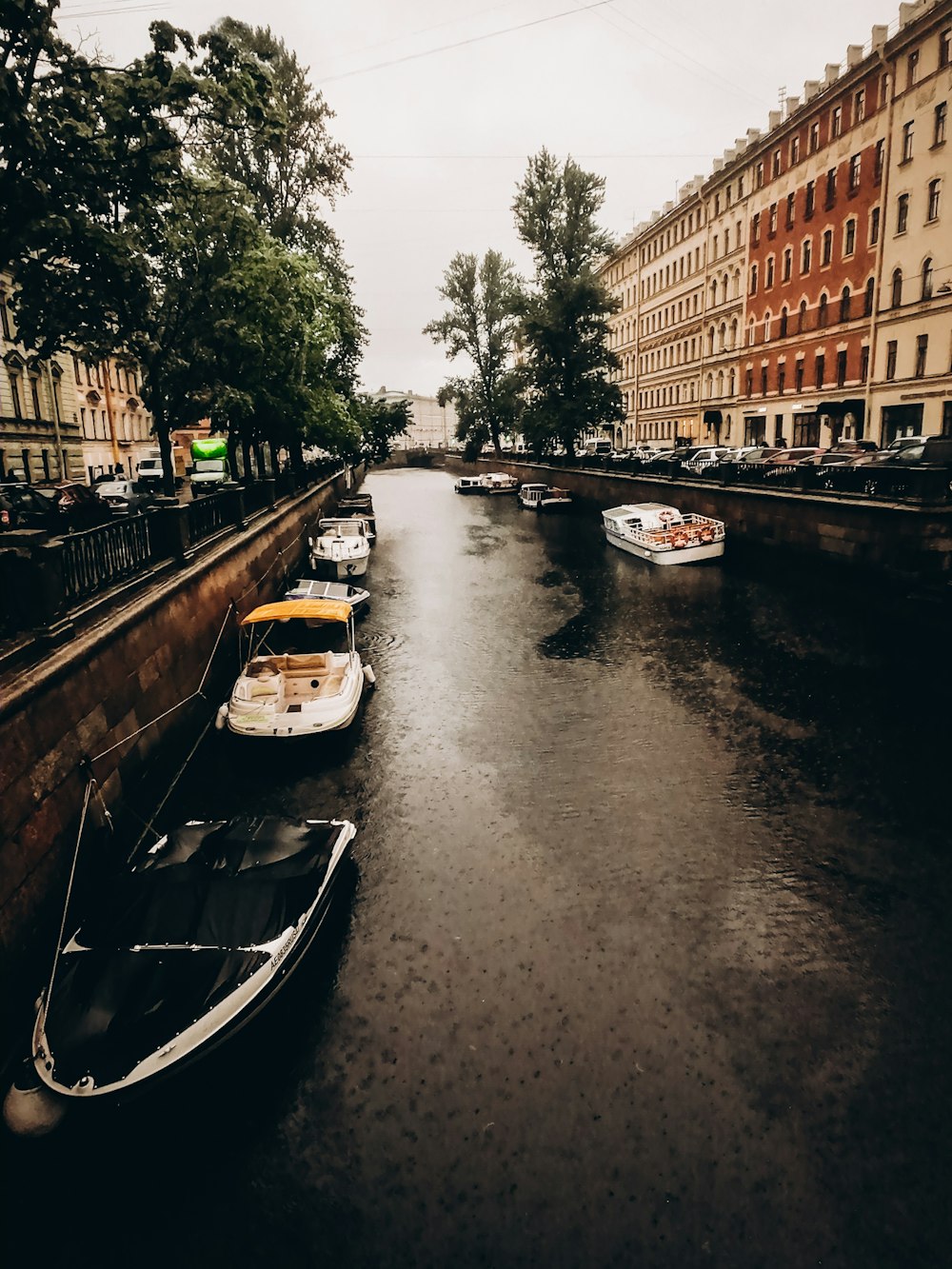 boats are parked along a canal in a city