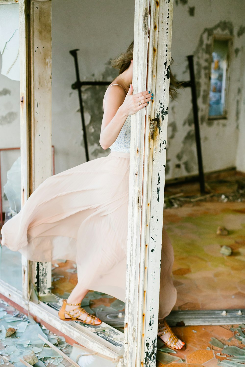 a woman in a pink dress leaning on a mirror