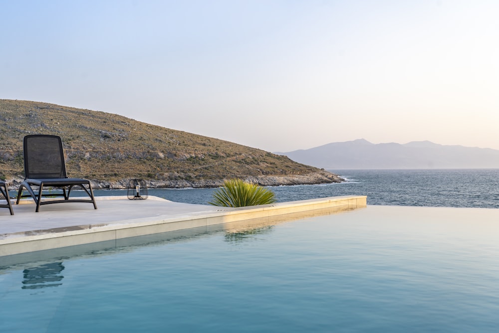 a chair sitting on the edge of a swimming pool