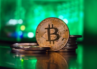 a bit coin sitting on top of a stack of coins