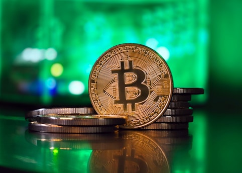 a bit coin sitting on top of a stack of coins