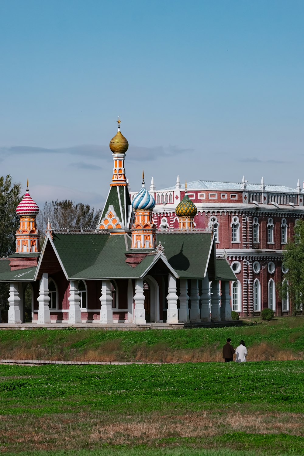 a large red and white building with a green roof