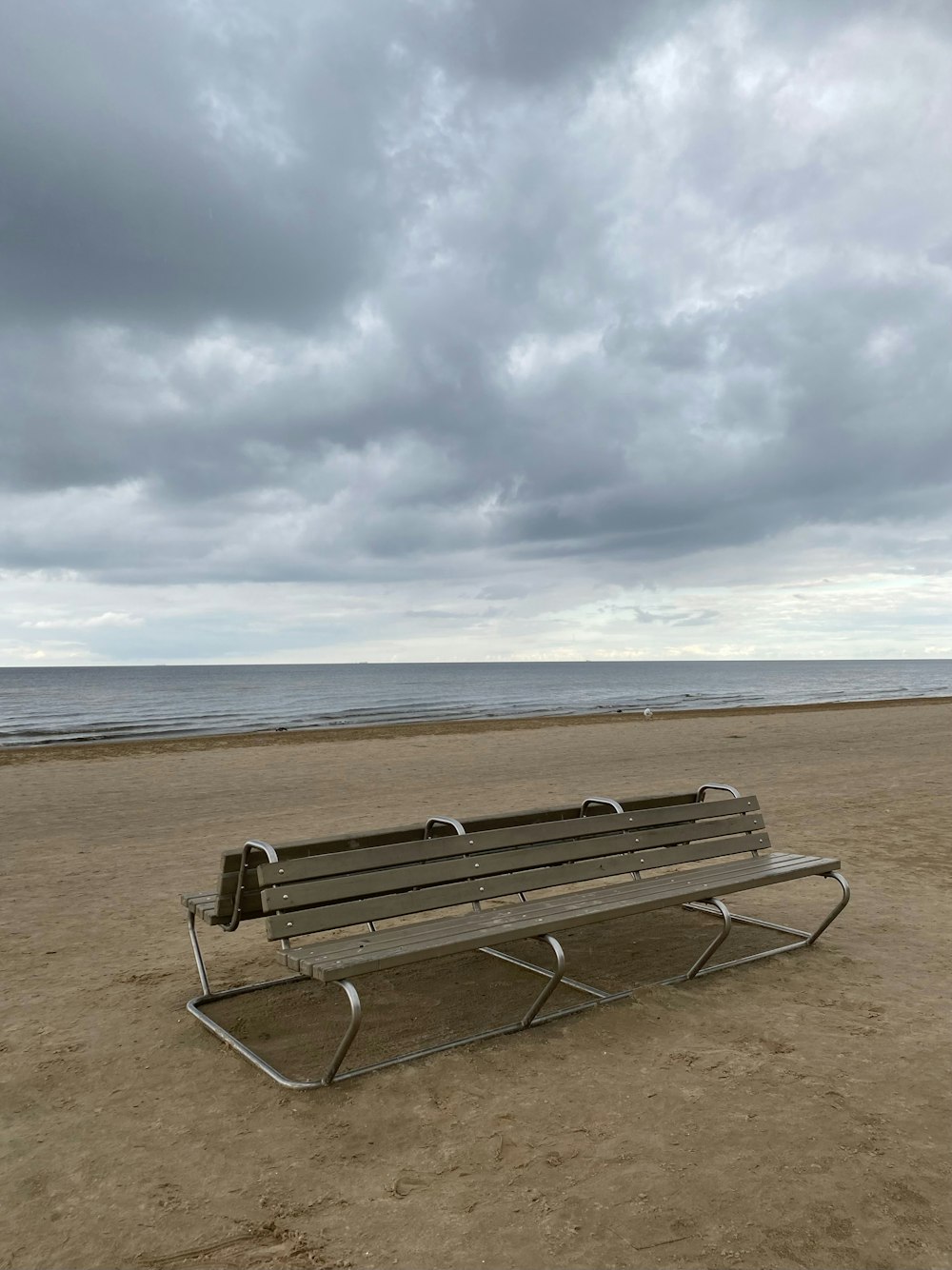 a bench sitting on top of a sandy beach