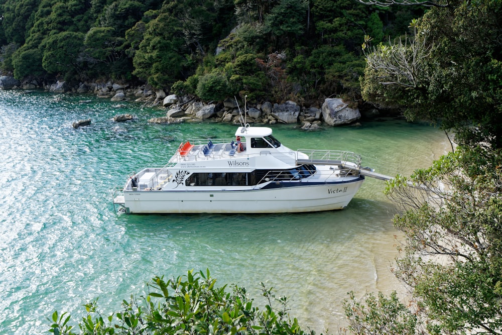 a white boat floating on top of a body of water