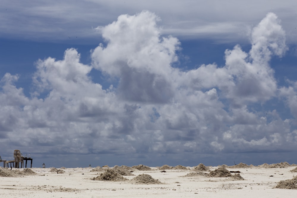 a group of people on a beach under a cloudy sky